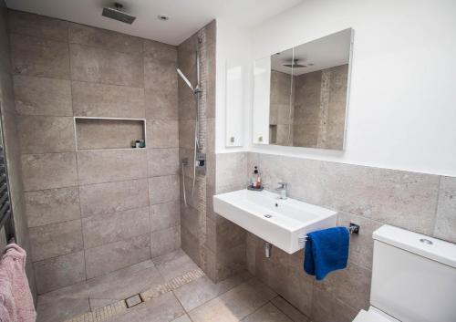 une salle de bain avec lavabo et douche dans l'établissement Serenity "your calm seafront retreat" By Air Premier, à Seaford