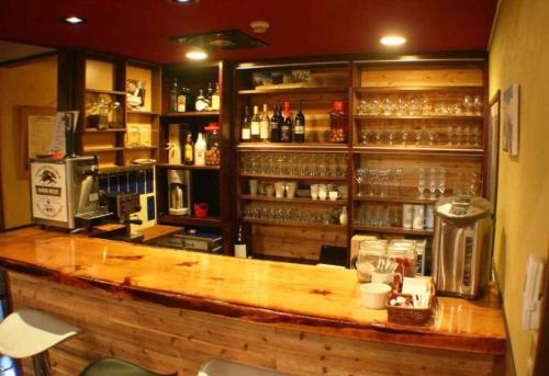 a bar in a restaurant with a counter with alcohol at Santana Lodge Hakuba in Hakuba