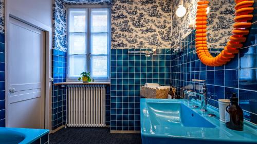 a bathroom with blue tiled walls and a blue tub at Le Prieuré d'Arbois in Arbois