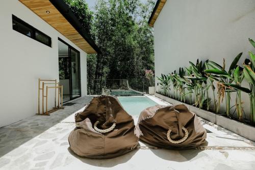 two bags on the ground next to a swimming pool at Villas Tamu 1 in Bingin Beach