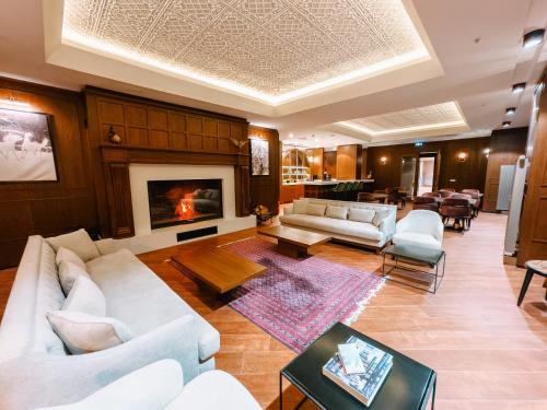 een woonkamer met witte banken en een open haard bij Liv Hotels Erciyes in Cebir