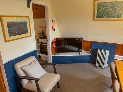 a small room with a bed and a chair at 1 Bedroom Cabin with Mountain & Loch Views - Quiet Location between Glencoe & Ben Nevis in Onich
