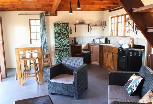 哈特比斯普特Oppiberg Cottage with River View的厨房配有两把椅子、一张桌子和炉灶