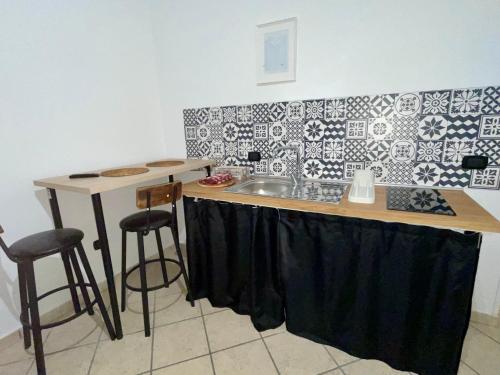 a kitchen with a sink and a counter with stools at Carioca Aparthotel in Capua