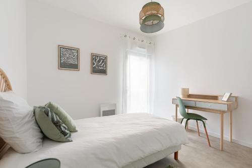 a white bedroom with a bed and a desk at Jolie maison de style bohème, douce et lumineuse in Bordeaux