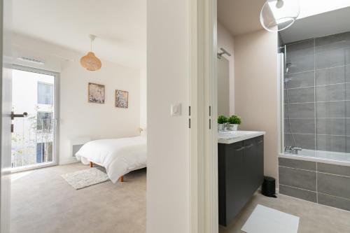 a bedroom with a bed and a bathroom with a shower at Jolie maison de style bohème, douce et lumineuse in Bordeaux