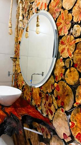 a bathroom with a mirror on a stone wall at Chalé Rio Capetinga 01 in Anchieta