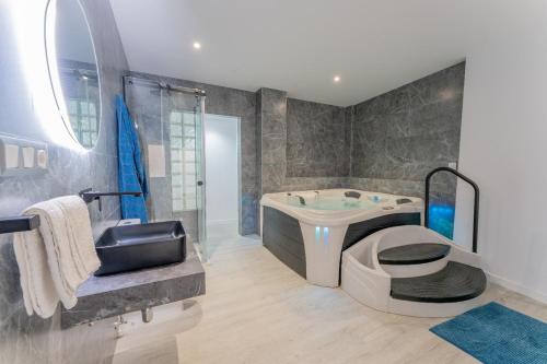 a bathroom with a tub and a toilet and a sink at Secrets Torrevieja in Torrevieja