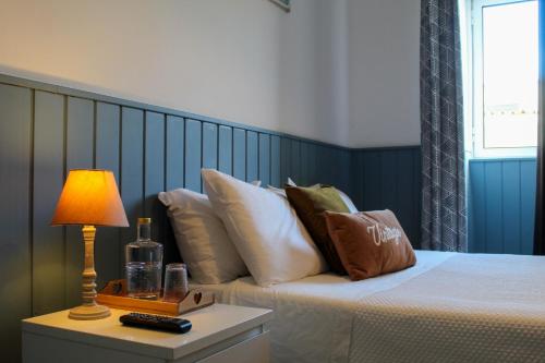 ein Schlafzimmer mit einem Bett und einer Lampe auf einem Tisch in der Unterkunft Vintage Place - Azorean Guest House in Ponta Delgada