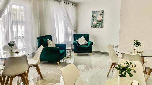 a living room with a table and chairs and a table and chairsktop at The M GuestHouse in Kempton Park