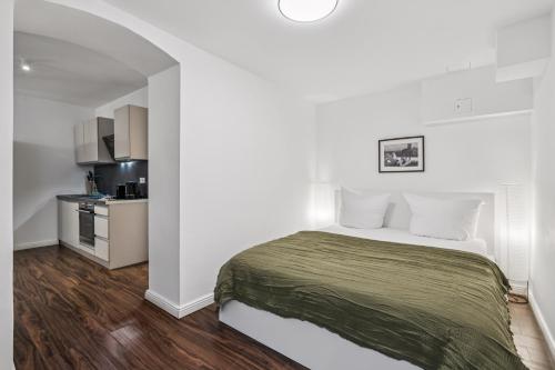 a bedroom with a bed and a small kitchen at Arbio I Stylish Apart Schöneberg S-Bahn in Berlin