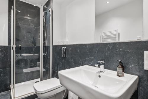 a bathroom with a sink and a toilet and a shower at Arbio I Stylish Apart Schöneberg S-Bahn in Berlin