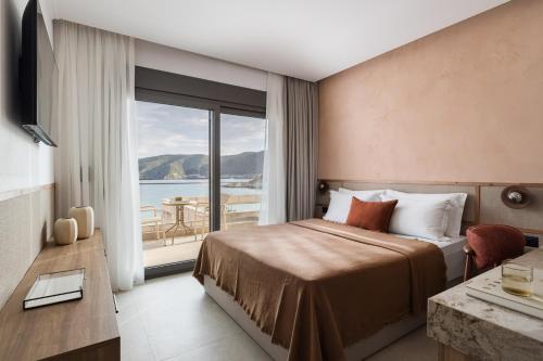 a hotel room with a bed and a large window at Orizon Boutique Rooms in Kalamitsi
