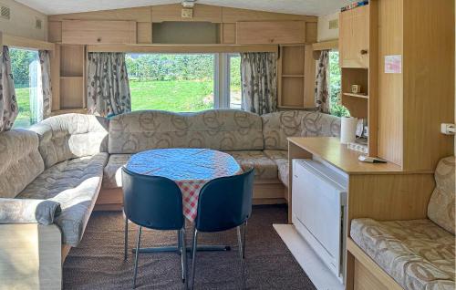 Cette caravane comprend un salon avec une table et un canapé. dans l'établissement 3 Bedroom Nice Home In Nexø, à Balke