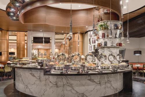 Un restaurante con un mostrador con comida. en Eastwood Richmonde Hotel Quezon City, en Manila