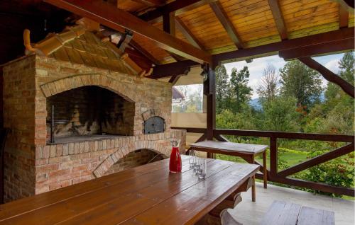 a stone fireplace in a patio with a wooden table at Amazing Apartment In Vrbovsko With Sauna in Vrbovsko