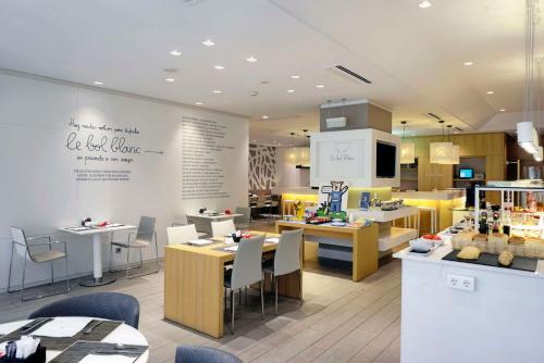 ビルバオにあるNH コレクション ヴィラ デ ビルバオのテーブルと椅子とキッチンのあるレストラン