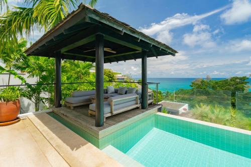 a pool with a gazebo next to a swimming pool at Surin Heights Villa in Surin Beach