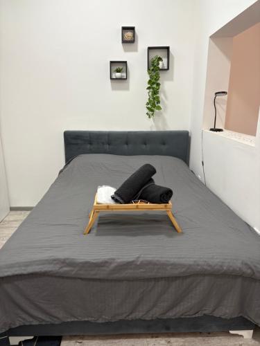 a bed with a wooden bed frame in a room at El Mundo Apartman in Bečej