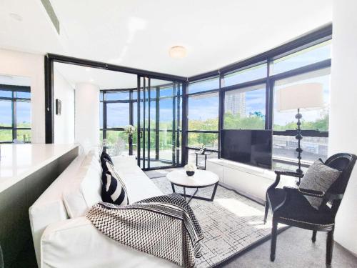 a living room with a white couch and a large window at Timeless Black n White Charm 2BR w Kids room in Sydney