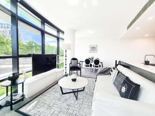 a living room with a white couch and a tv at Timeless Black n White Charm 2BR w Kids room in Sydney