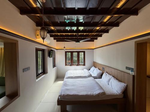 - 2 lits dans une chambre avec un plafond à caissons dans l'établissement Mangrove Heritage Home, Chendamangalam, à Cochin