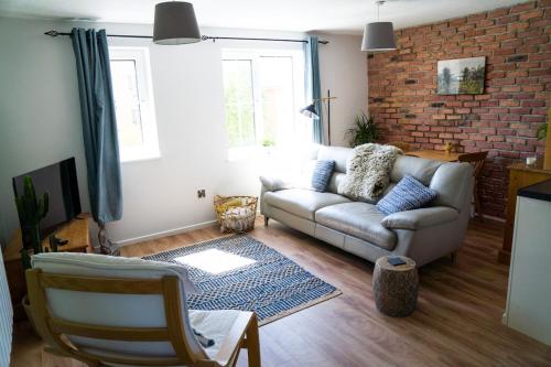 a living room with a couch and a brick wall at Modern flat in Cardiff Bay in Cardiff