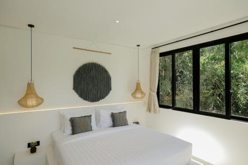 a bedroom with a white bed and a window at Villas Tamu 4 in Bingin Beach