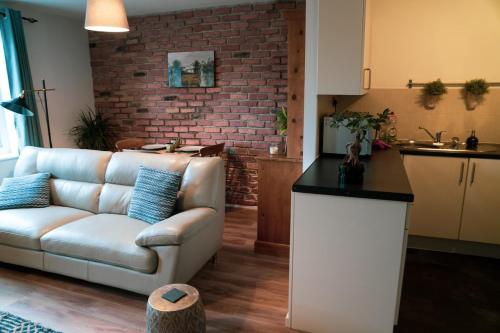 a living room with a couch and a brick wall at Modern flat in Cardiff Bay in Cardiff