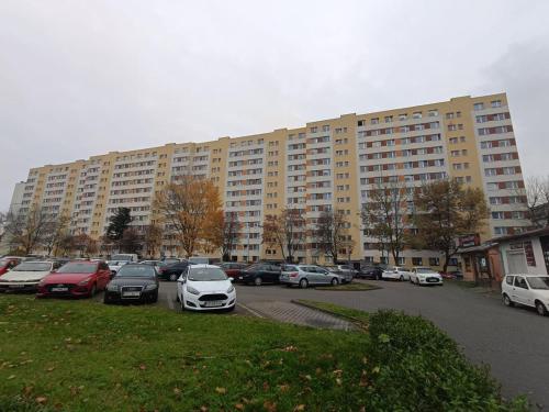a large building with cars parked in a parking lot at Piotrków Trybunalski Comfort Apartment by BookingHost in Piotrków Trybunalski