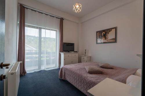 a bedroom with a bed and a large window at Pensiunea All Seasons in Iaşi