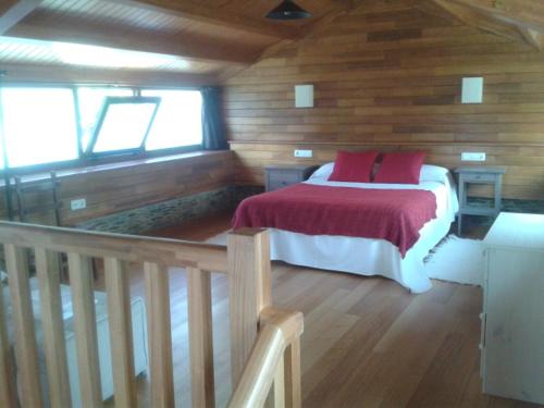 a bedroom with a bed in a wooden cabin at A Cabana de Cao in Loiba