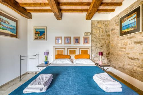 a bedroom with a large blue bed in a stone wall at Agriturismo Le Sorgenti in Pieve san Nicolo