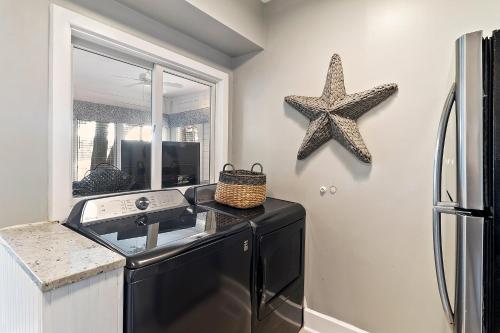 Una cocina con un lavavajillas negro y una estrella de mar en la pared. en TP4937: 4937 Turtle Point, en Kiawah Island