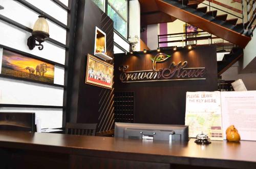 a bar in a restaurant with a sign on the wall at Erawan House in Bangkok