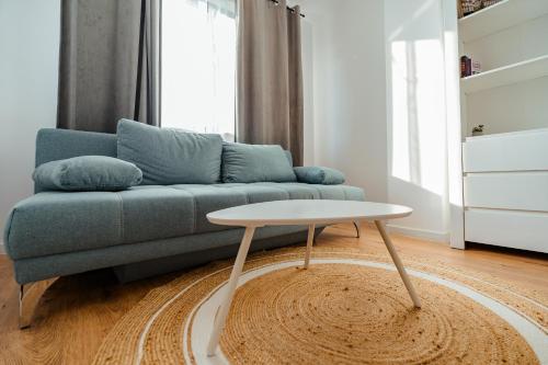 un salon avec un canapé bleu et une table dans l'établissement Ivory by Blvd 25B4 - Premium Studio with Garden View, à Bucarest