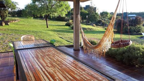 een hangmat op een patio met uitzicht op een veld bij CuyenCo Casa de campo in Santa Rosa de Calamuchita