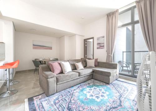 a living room with a couch and a table at Free housekeeping visits during your stay - StayShort - Dubai South 1BR sleeps 4 in Dubai Marina