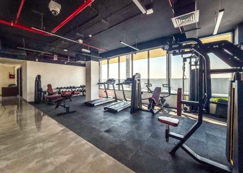 a gym with several treadmills and machines in a room at Free housekeeping visits during your stay - StayShort - Dubai South 1BR sleeps 4 in Dubai Marina