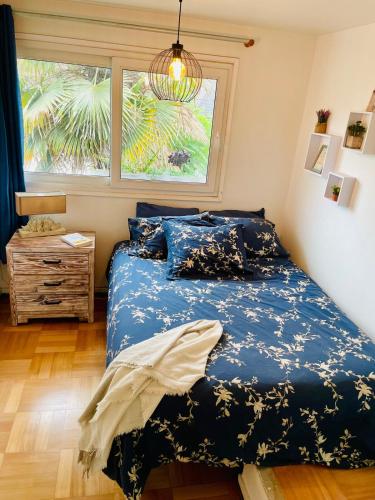 a bedroom with a bed with a blue comforter and a window at Central Santiago Haven in Santiago