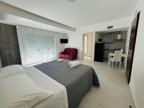Un dormitorio con una cama grande y una silla roja. en Aqua Marine B&B - Rooms and Apartments, en Milazzo