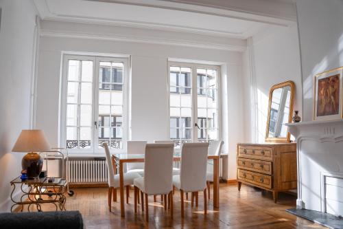 een eetkamer met een tafel en witte stoelen bij La Belle Époque Apartment in Luxemburg