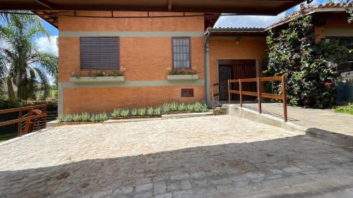 una casa con una entrada de ladrillo delante de ella en Café e Pousada Jardim Secreto, en Santa Rita do Sapucaí