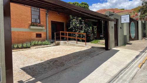 un edificio con toldo al lado de una calle en Café e Pousada Jardim Secreto, en Santa Rita do Sapucaí