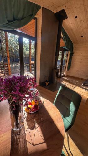 a vase of flowers on a table in a room at Equi Lis - будиночки для відпочинку in Yasnogorodka
