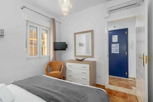a bedroom with a bed and a mirror and a chair at Playa Grande by H- Playa Punta del Moral PPHG136P111 in Isla del Moral