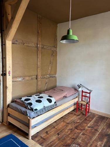 a bed in a room with a chair and a lamp at Entschleunigen im Fachwerkhaus am Wald in Vielank