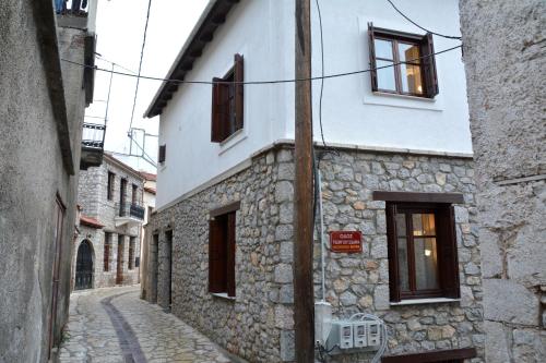 a stone building with windows on a street at Αρσινόη apartments 4 in Arachova