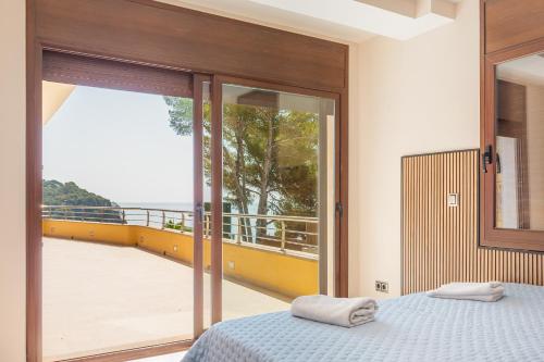 a bedroom with a bed and a view of a balcony at Villa con Infinity pool in Lloret de Mar