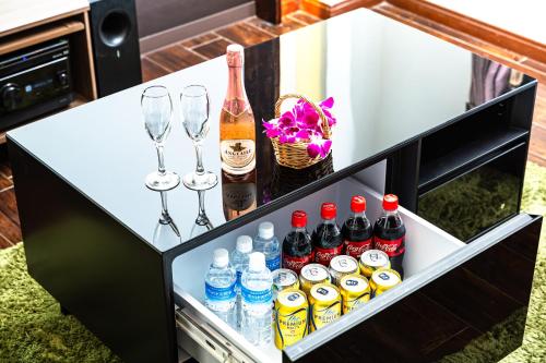 a refrigerator with drinks and wine bottles and wine glasses at Hotel Balian Resort Tomei Kawasaki I.C. in Kawasaki